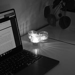 a laptop and lit candles on the desk