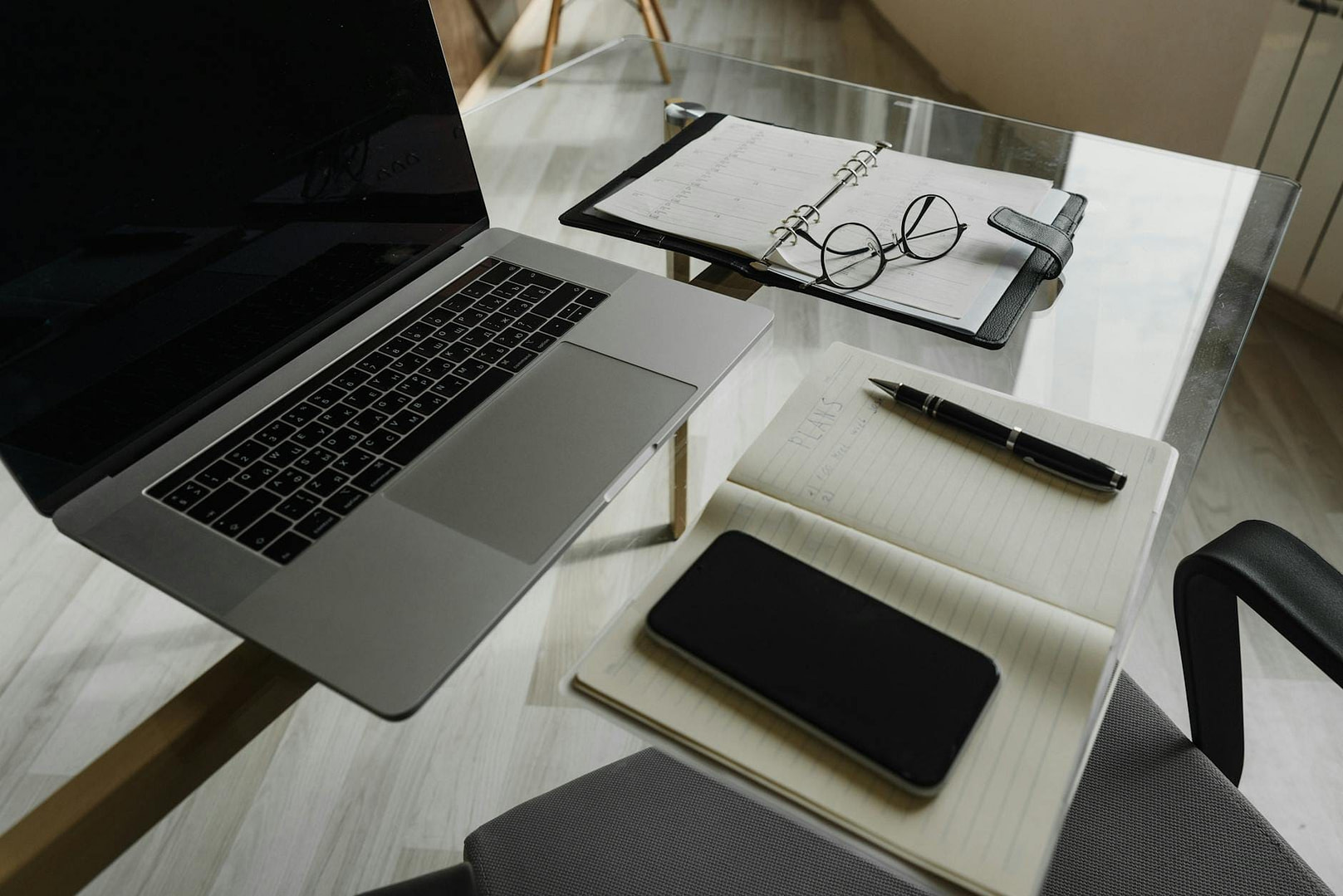 Market Research for Digital Products: The Launch Blueprint 8 a glass table with a laptop and a notebook