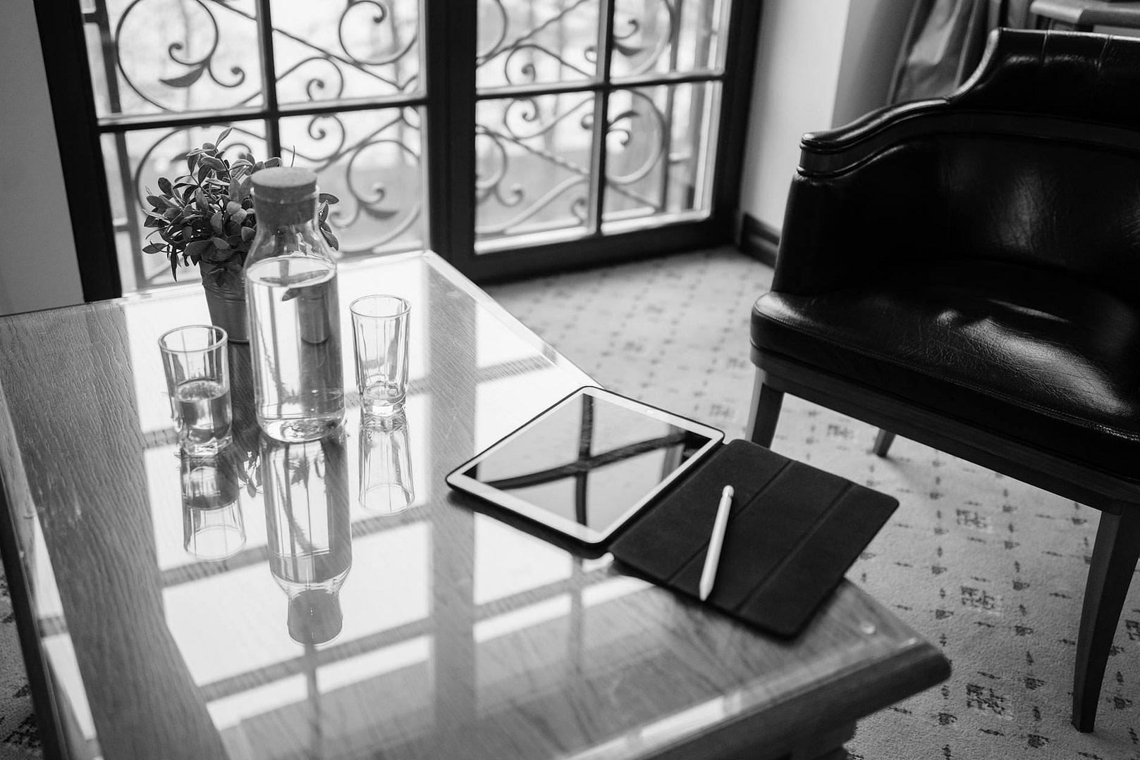 a room with digital tablet on table and drinking glasses with glass bottle of water