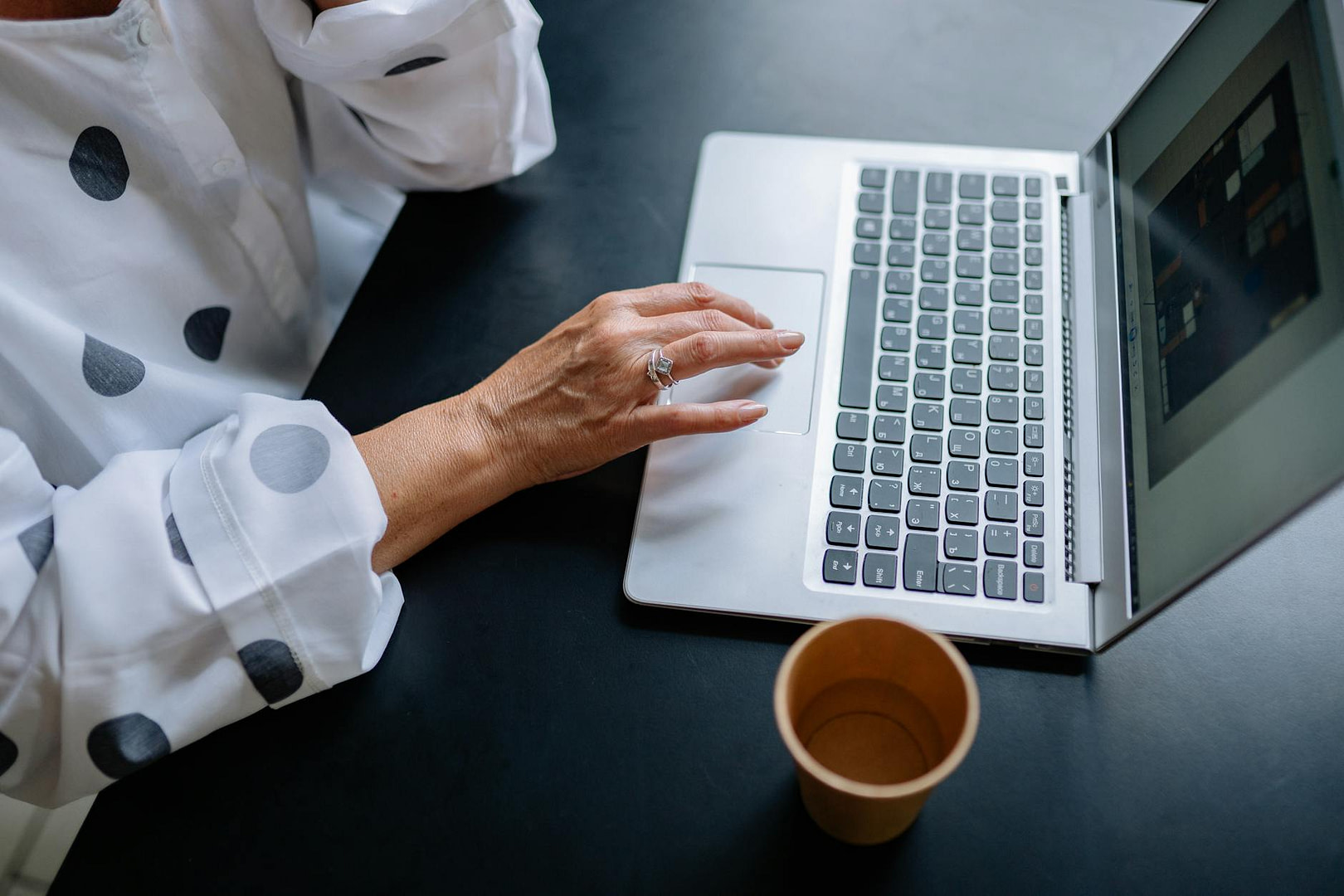 person using a laptop on black table