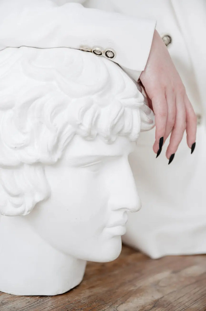 a close up shot of a person leaning on a head figurine