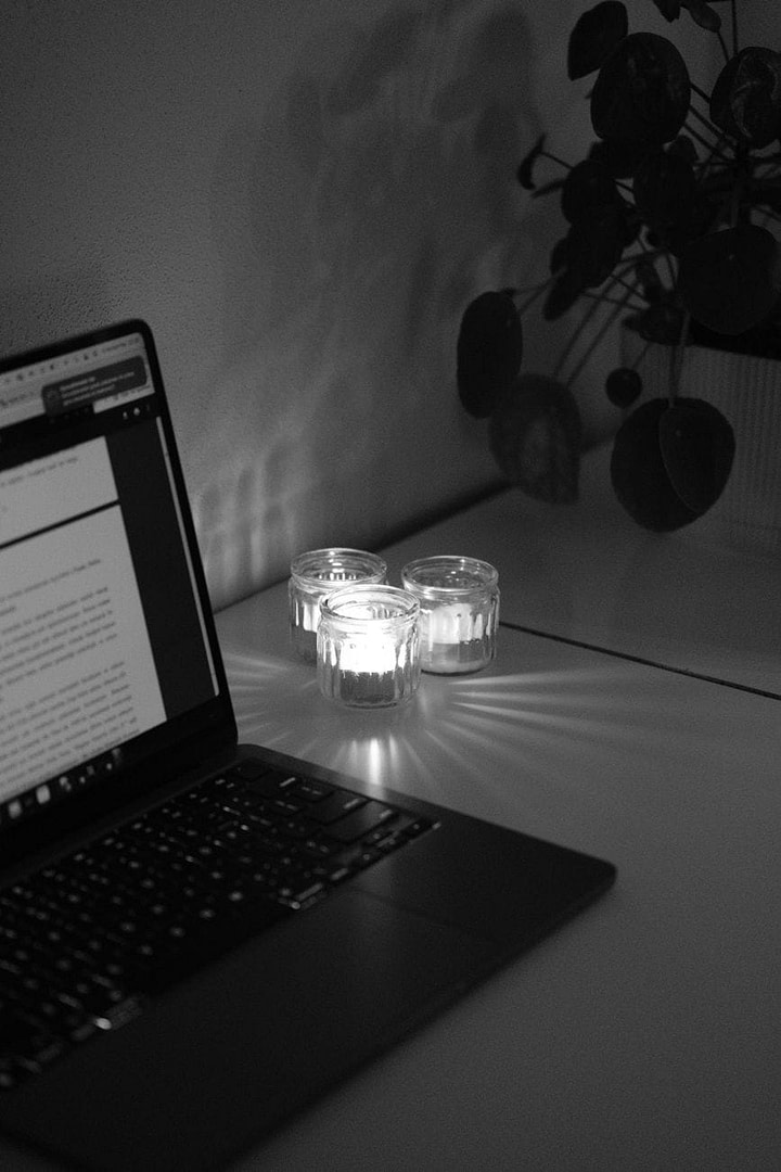 Niche Product Examples for 2026: 30+ Profitable Ideas That Print Money (While Everyone Else Fights Over Scraps) 4 a laptop and lit candles on the desk